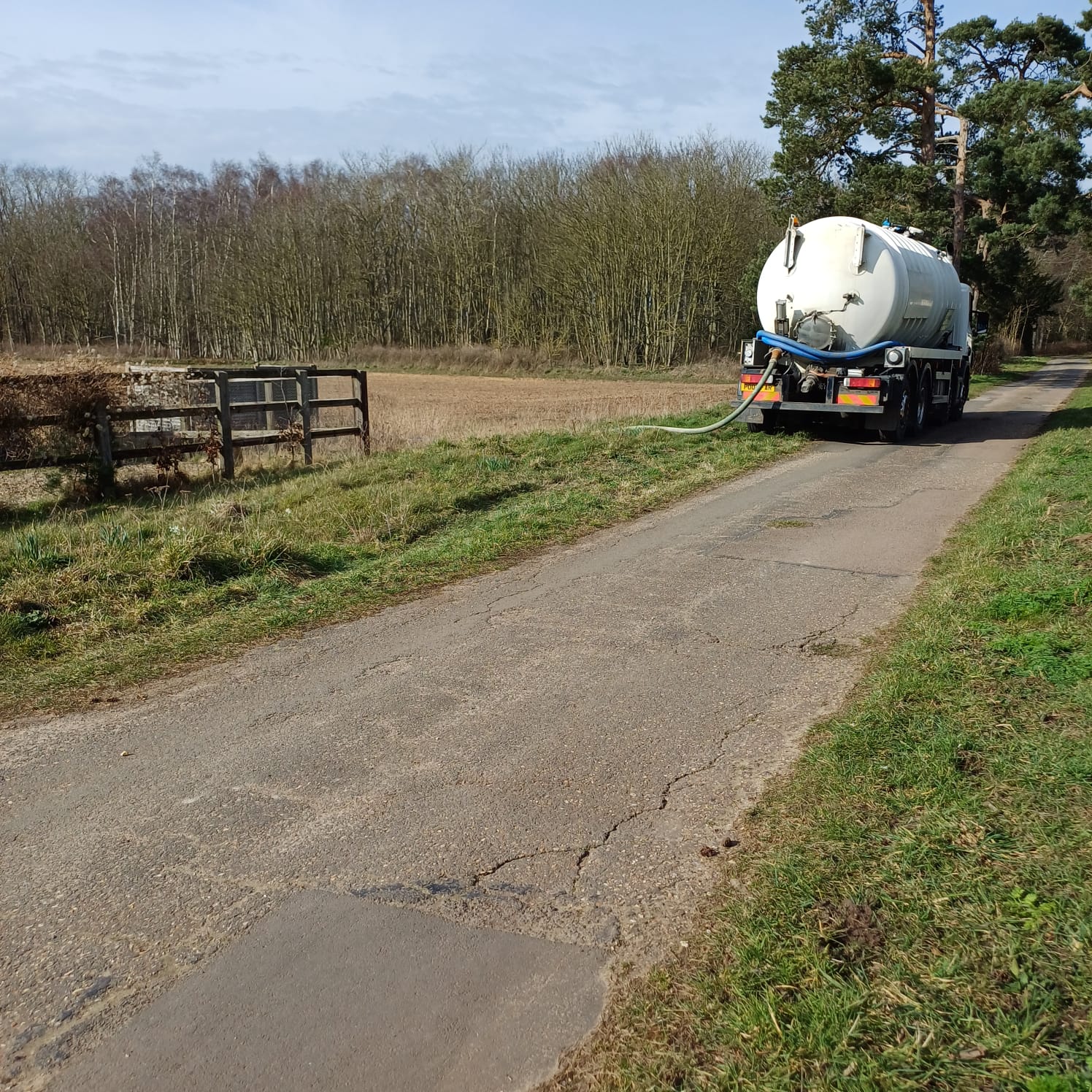 Tanker on a rural track beside farmland